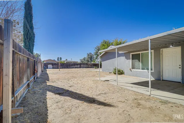 a view of a house with backyard and trees