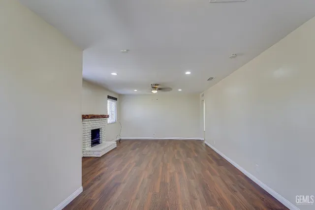 a view of empty room with wooden floor and window