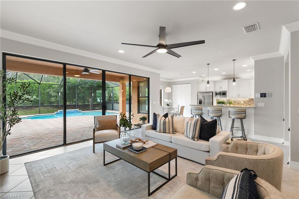 4384 Aurora Street Naples, FL 34119 - Photo 11 of 47 a living room with furniture and a large window