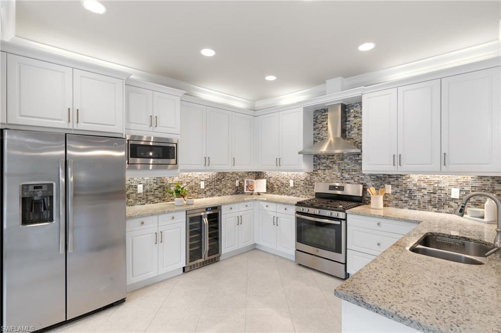 4384 Aurora Street Naples, FL 34119 - Photo 15 of 47 a kitchen with a sink stove and refrigerator