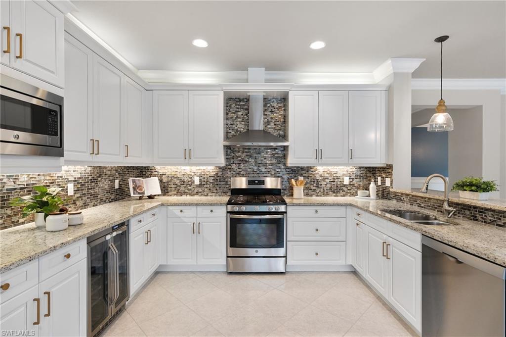 4384 Aurora Street Naples, FL 34119 - Photo 17 of 47 a kitchen with stainless steel appliances granite countertop a stove and white cabinets