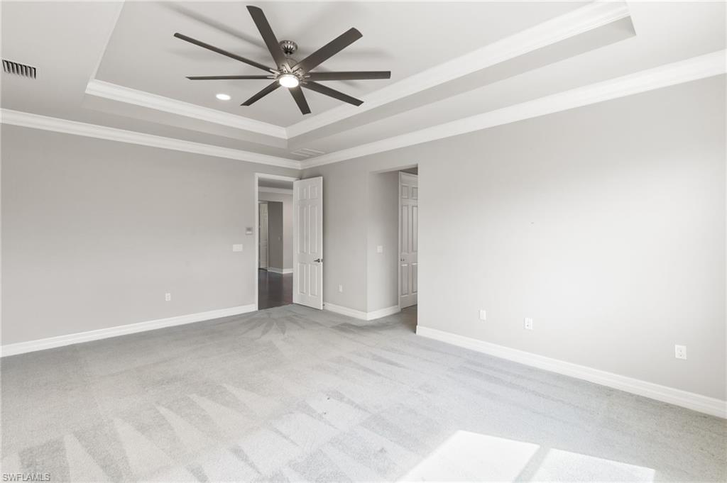 4384 Aurora Street Naples, FL 34119 - Photo 21 of 47 an empty room with windows and ceiling fan