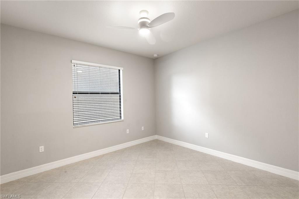 4384 Aurora Street Naples, FL 34119 - Photo 27 of 47 an empty room with a window and a ceiling fan