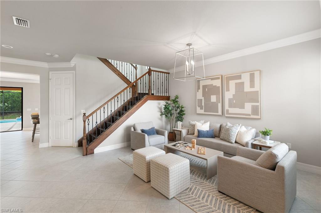 4384 Aurora Street Naples, FL 34119 - Photo 3 of 47 a living room with furniture and a chandelier
