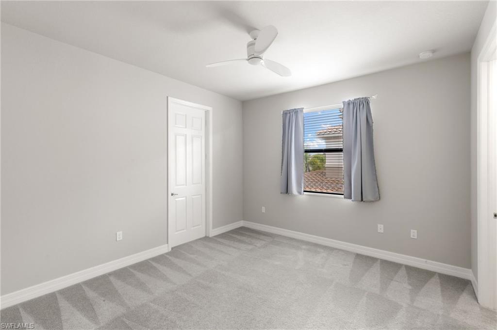 4384 Aurora Street Naples, FL 34119 - Photo 35 of 47 an empty room with windows and ceiling fan
