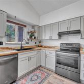 a kitchen with cabinets appliances a sink and a window