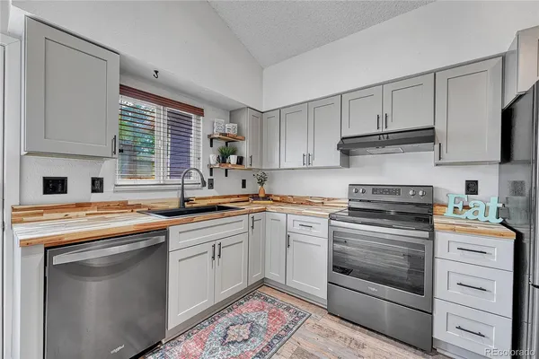 a kitchen with cabinets appliances a sink and a window