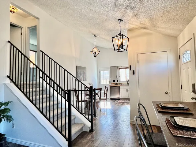 a view of a hallway with wooden floor and staircase