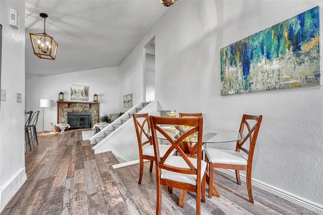 a dining room with furniture a fireplace and wooden floor