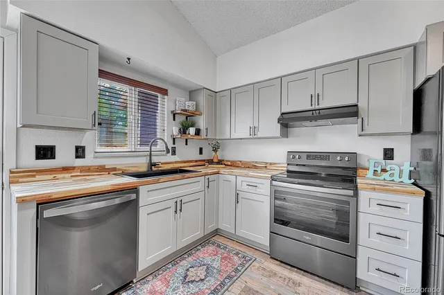 a kitchen with cabinets appliances a sink and a window
