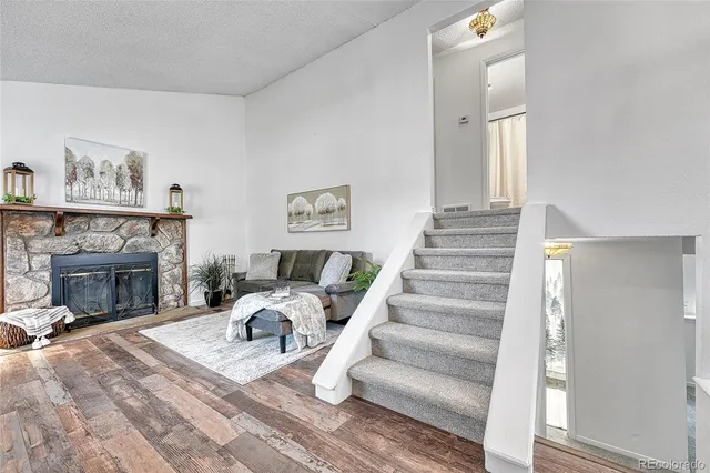 a view of a livingroom with a fireplace a ceiling fan and a bathtub