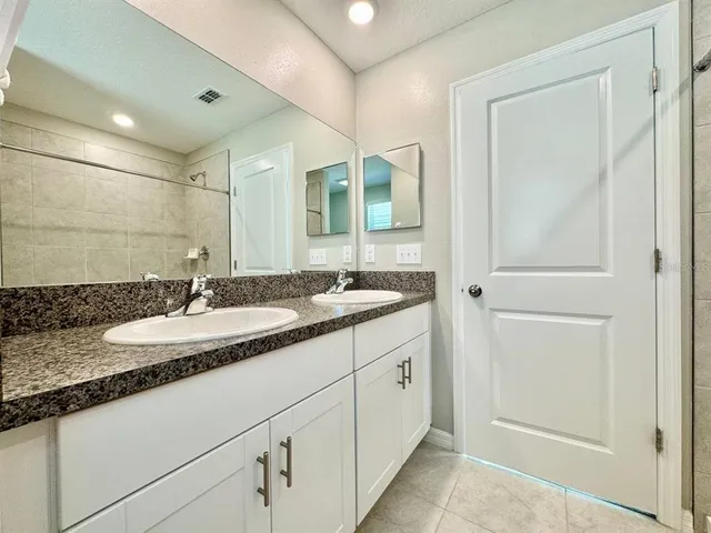 a bathroom with a granite countertop sink and a mirror