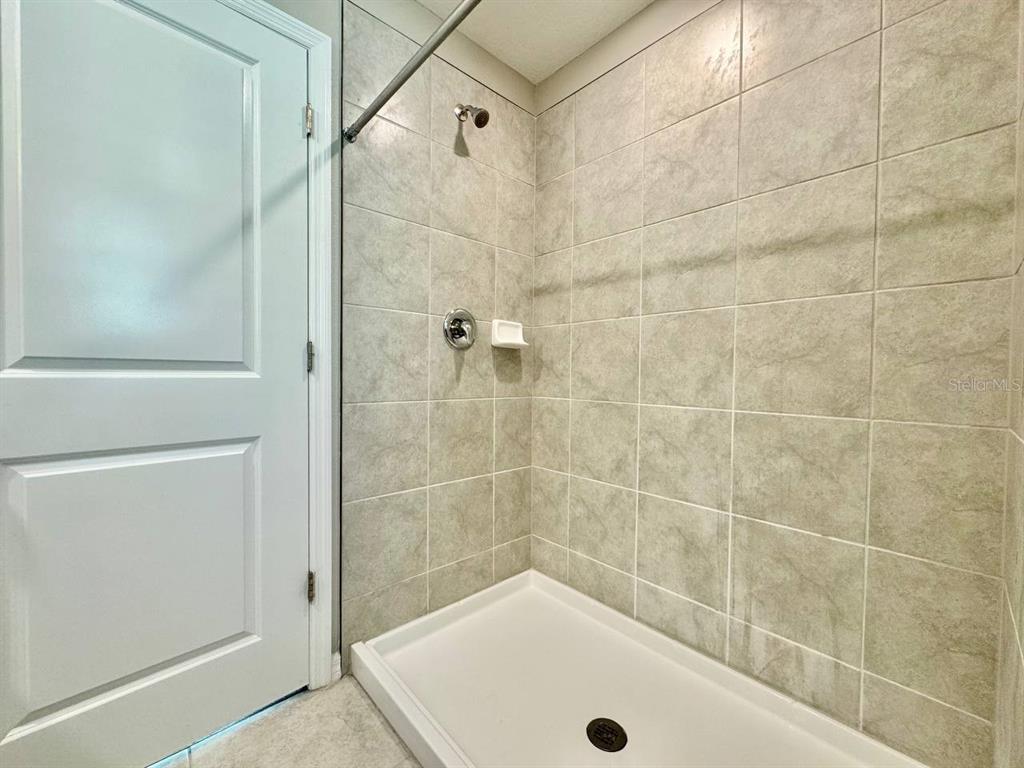 7020 Samuel Ivy Drive Tampa, FL 33619 - Photo 17 of 41 a bathroom with a tub and a shower
