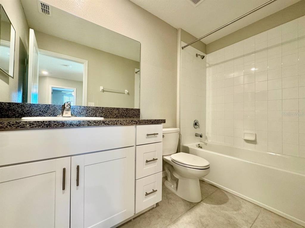 7020 Samuel Ivy Drive Tampa, FL 33619 - Photo 21 of 41 a bathroom with a granite countertop toilet sink and a mirror
