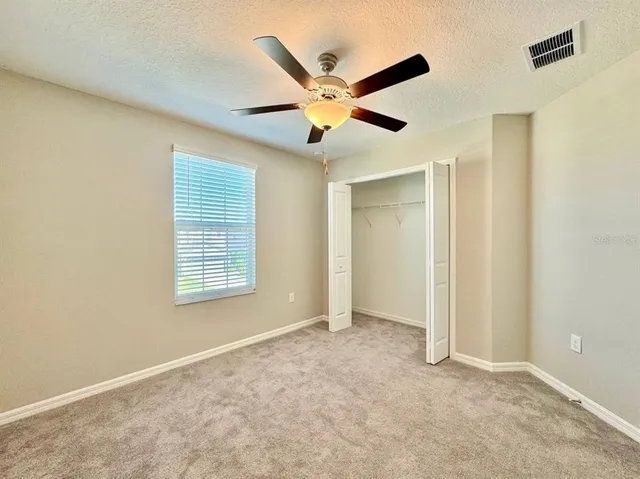 a view of an empty room with a ceiling fan