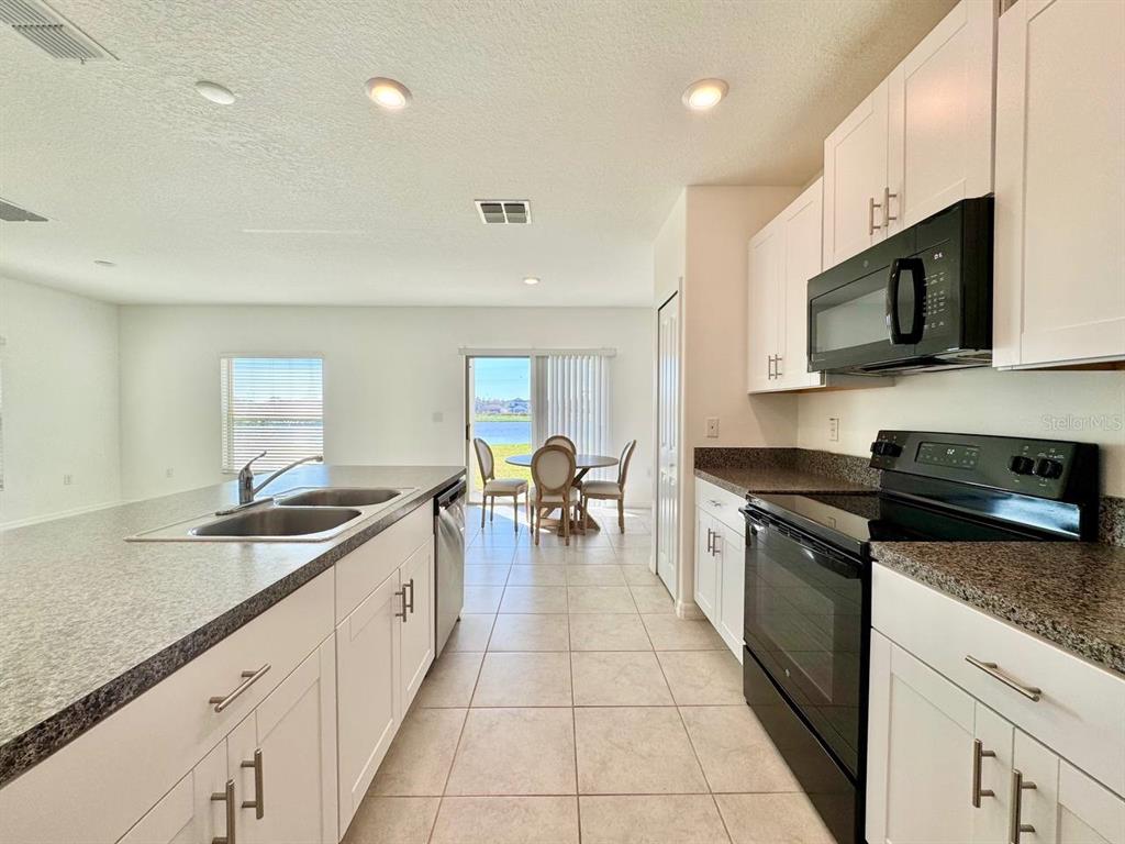 7020 Samuel Ivy Drive Tampa, FL 33619 - Photo 6 of 41 a large kitchen with stainless steel appliances granite countertop a sink and cabinets