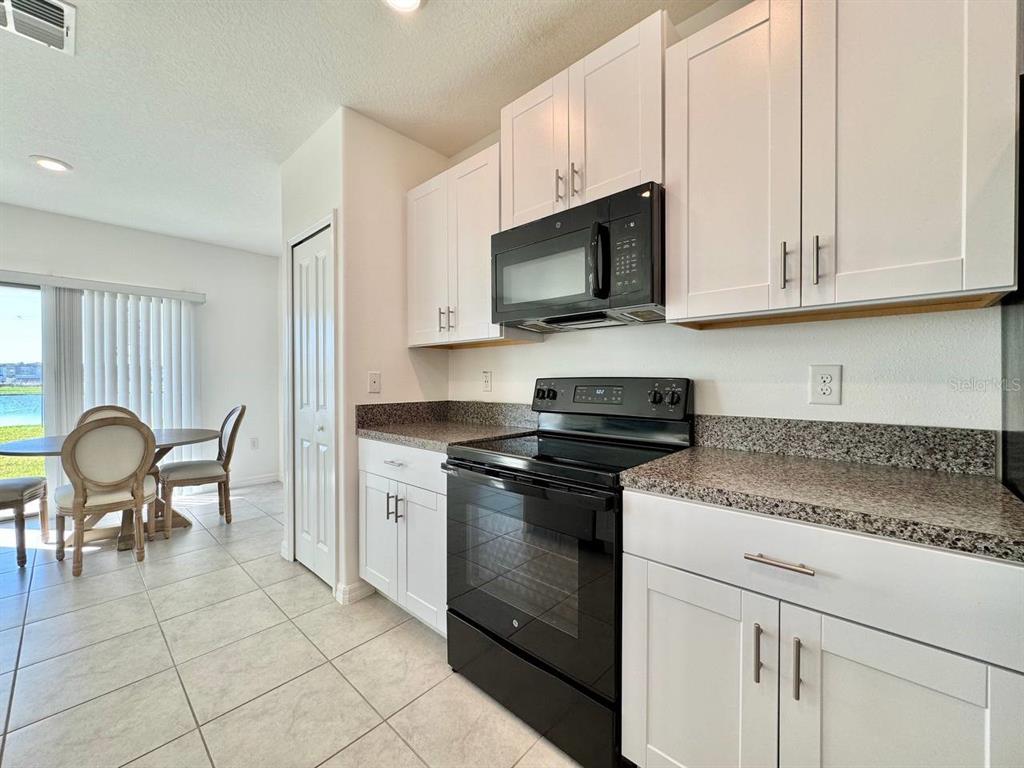7020 Samuel Ivy Drive Tampa, FL 33619 - Photo 7 of 41 a kitchen with stainless steel appliances granite countertop a stove a sink and a microwave