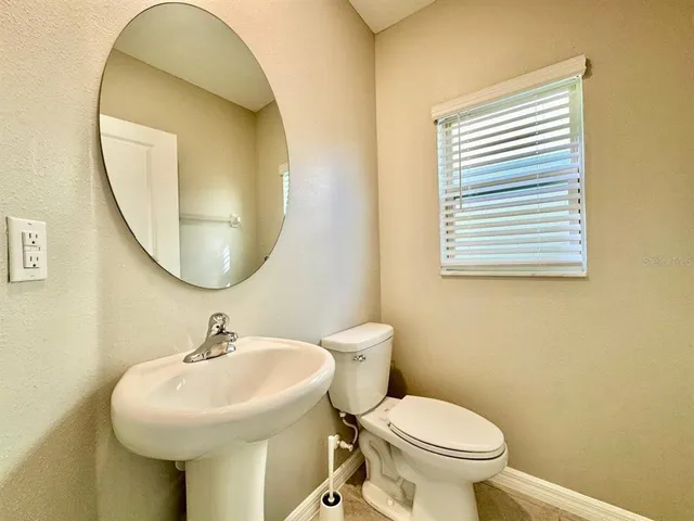 a bathroom with a sink a mirror and a toilet