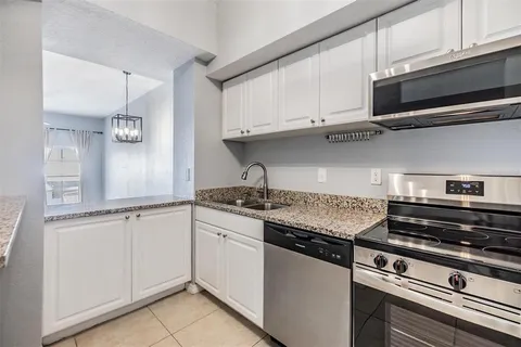 a kitchen with stainless steel appliances granite countertop a sink and a stove