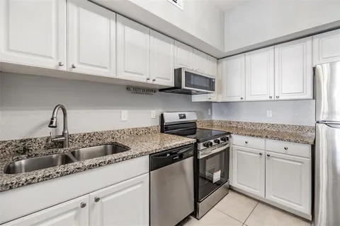 a kitchen with stainless steel appliances granite countertop a sink stove and cabinets