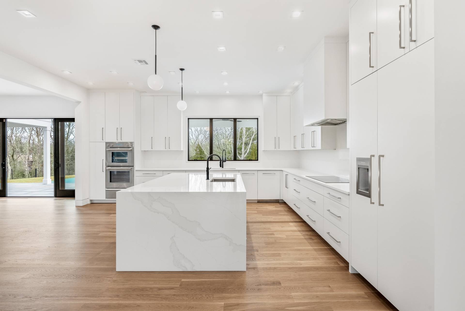 95 Highview Drive Sag Harbor, NY 11963 - Photo 6 of 22 a large white kitchen with a large window and stainless steel appliances