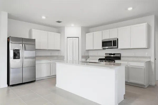 a kitchen with cabinets stainless steel appliances and a counter space
