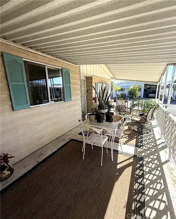 a view of a patio with table and chairs with wooden floor and fence