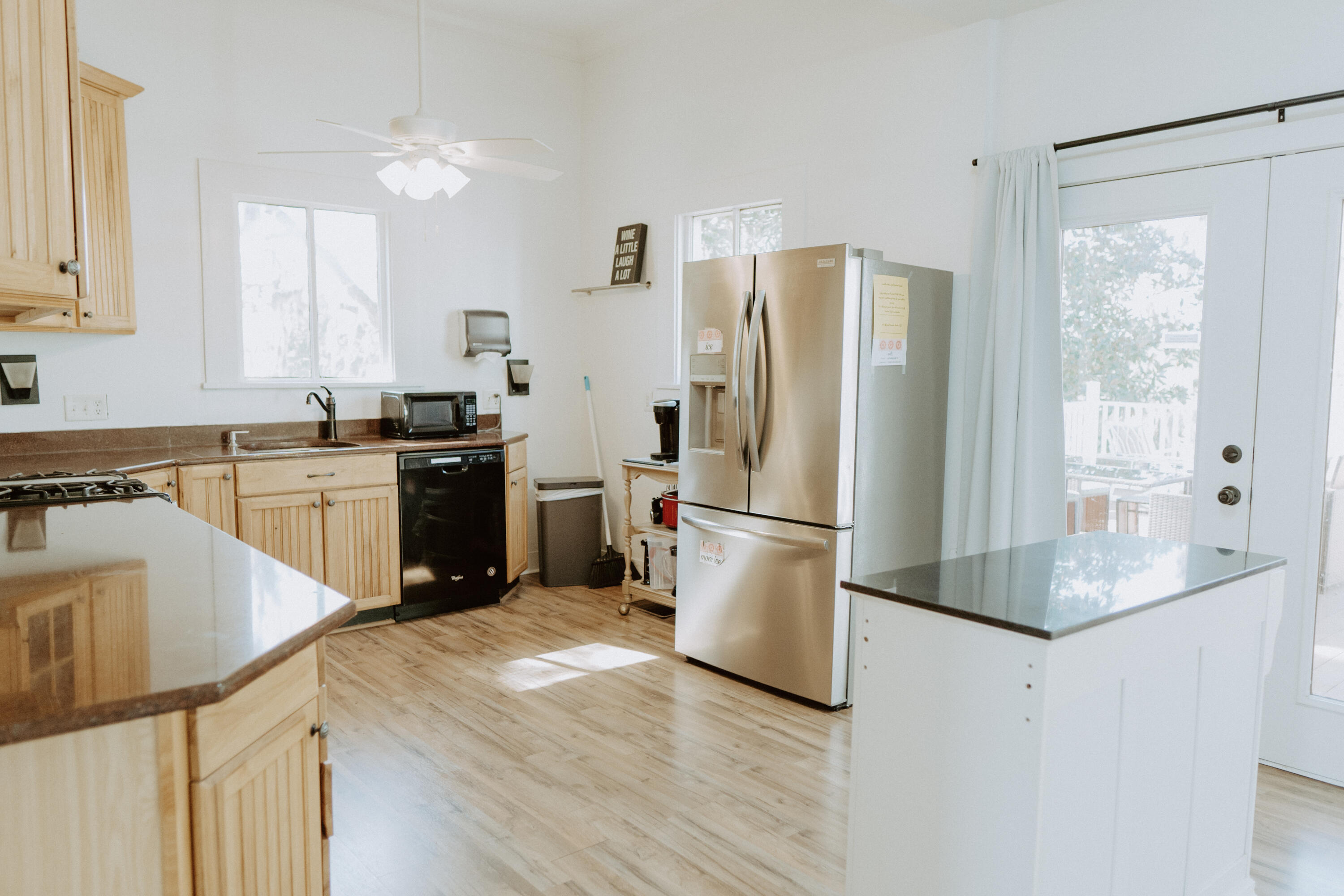 23622 Fifth Avenue Florala, AL 36442 - Photo 69 of 91 a kitchen with granite countertop a refrigerator a stove a sink dishwasher and white cabinets with wooden floor