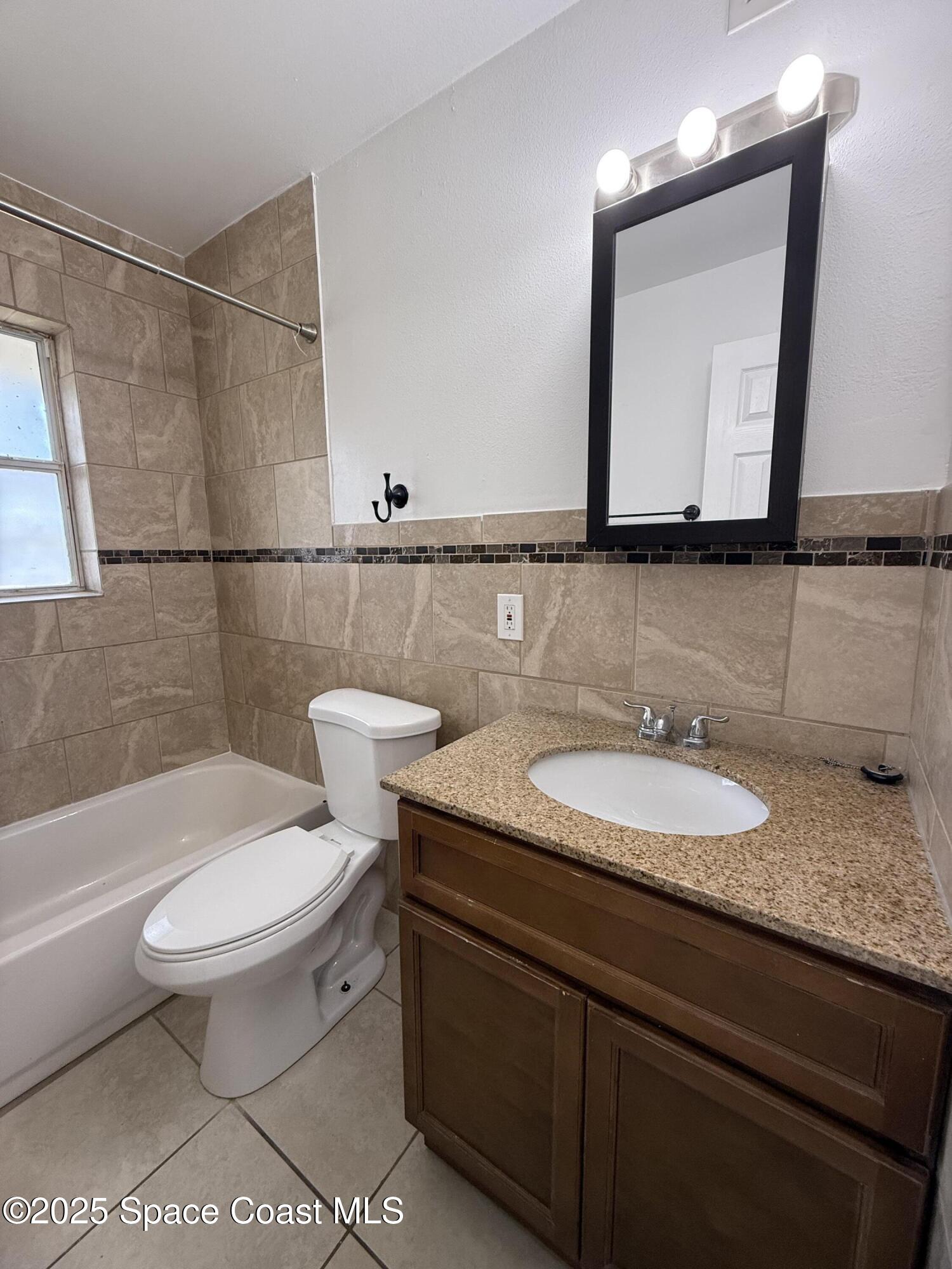 1440 Parkway Drive, Unit 7A Melbourne, FL 32935 - Photo 14 of 27 a bathroom with a granite countertop toilet sink and mirror