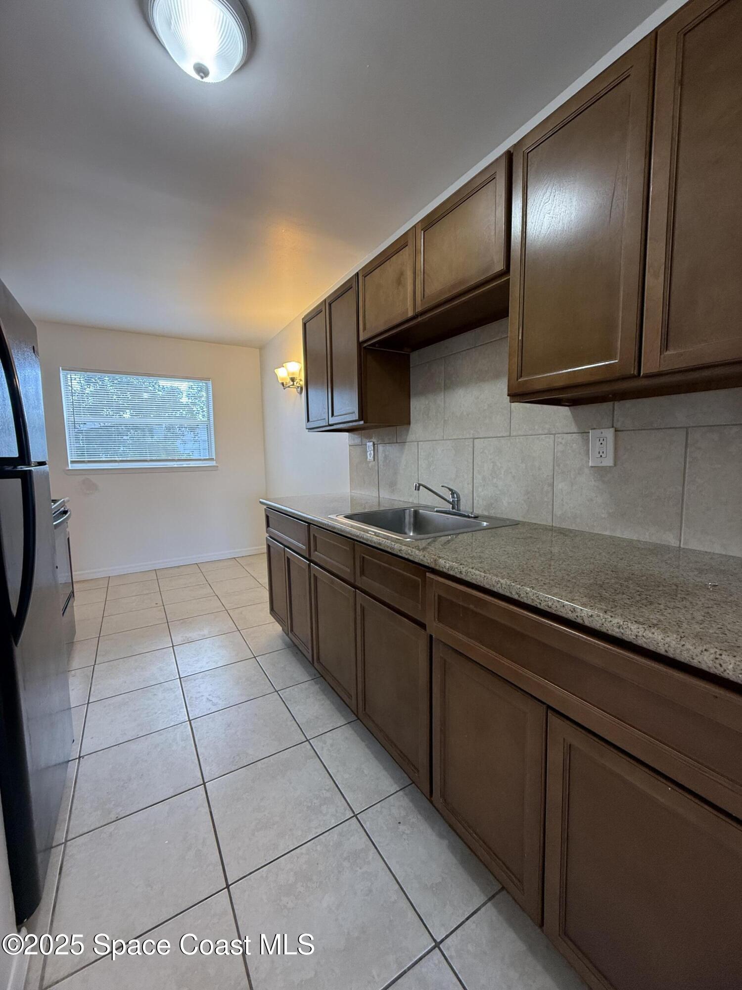 1440 Parkway Drive, Unit 7A Melbourne, FL 32935 - Photo 3 of 27 a kitchen with stainless steel appliances granite countertop a sink and cabinets