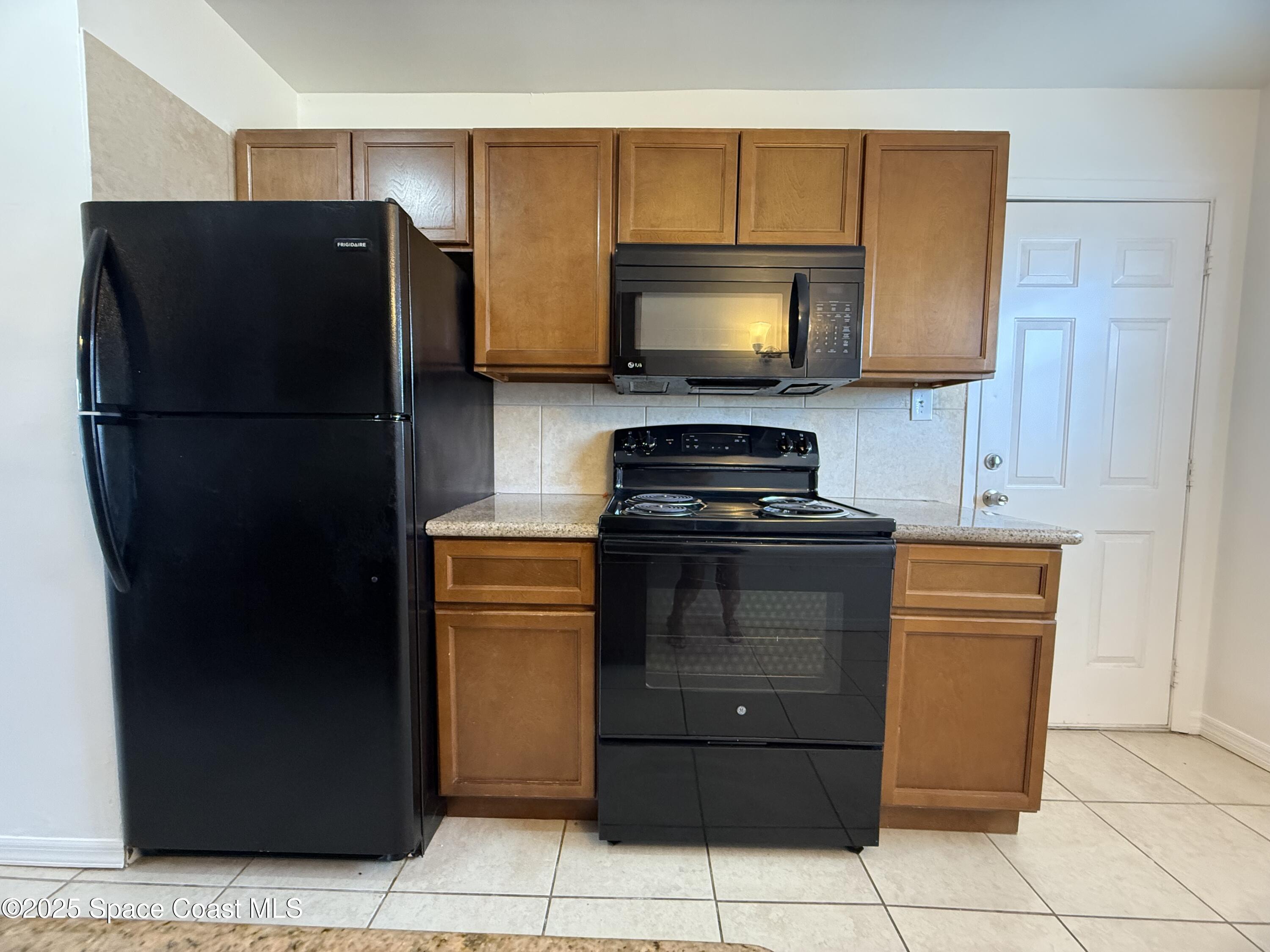 1440 Parkway Drive, Unit 7A Melbourne, FL 32935 - Photo 5 of 27 a kitchen with a refrigerator and a stove