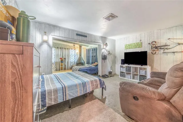 a bedroom with a bed a flat screen tv and a couch