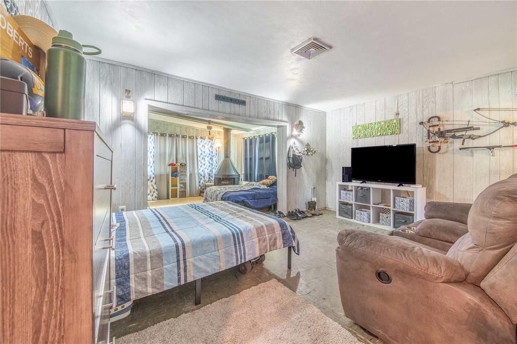 308 Granada Road Auburndale, FL 33823 - Photo 11 of 37 a bedroom with a bed a flat screen tv and a couch