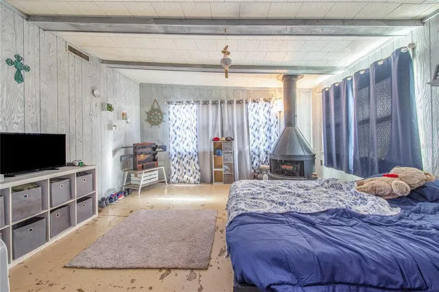 a bedroom with a bed a window and television