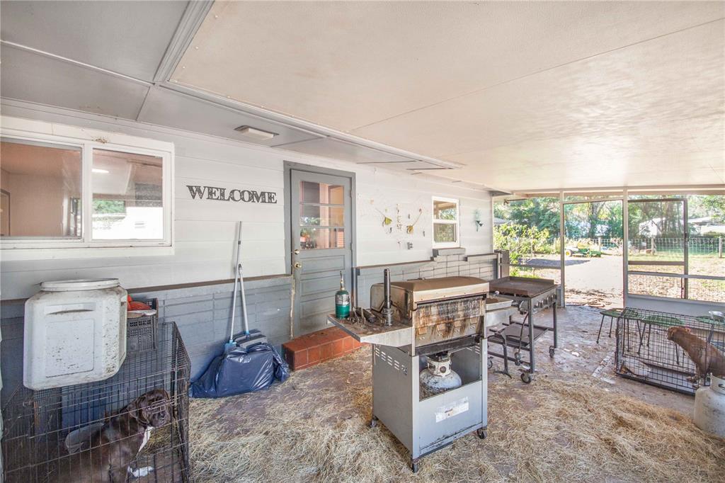 308 Granada Road Auburndale, FL 33823 - Photo 22 of 37 a living room with furniture a flat screen tv and a floor to ceiling window