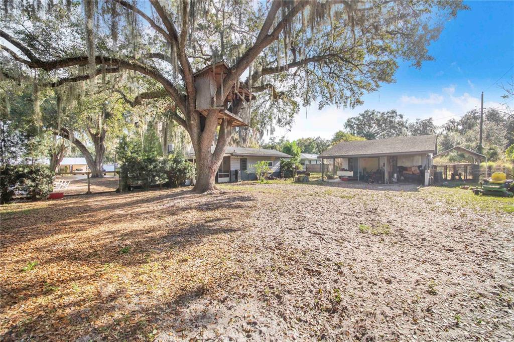 308 Granada Road Auburndale, FL 33823 - Photo 30 of 37 a front view of a house with a yard and large trees