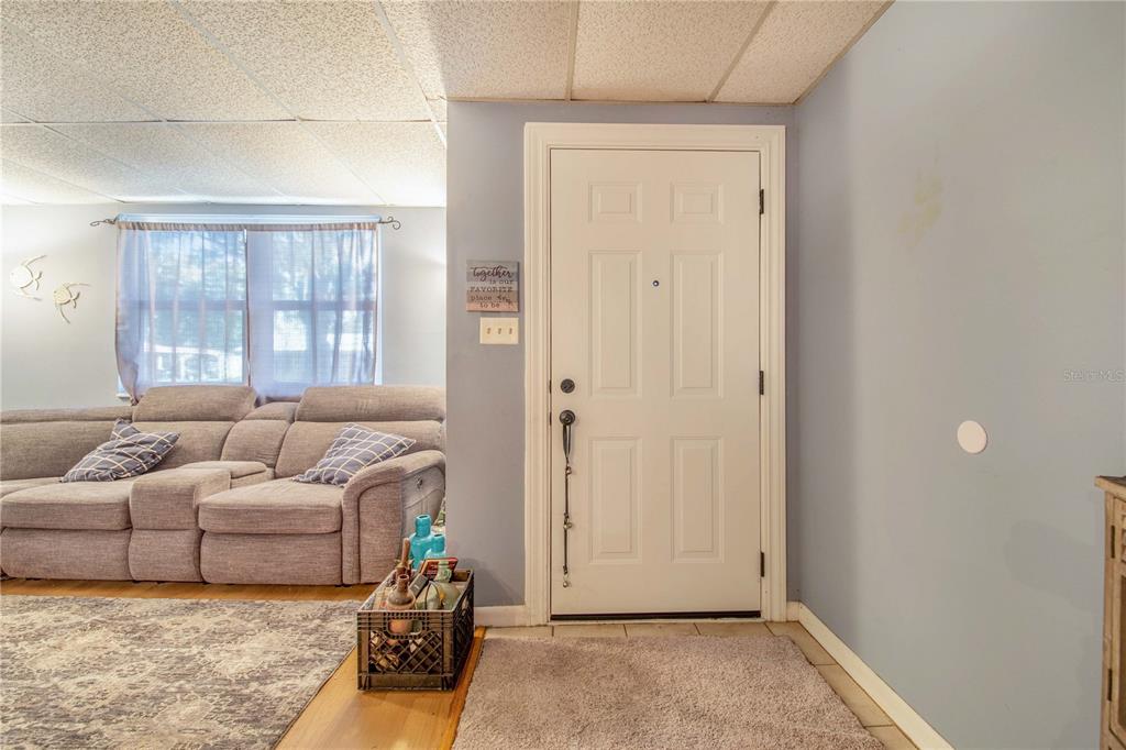 308 Granada Road Auburndale, FL 33823 - Photo 4 of 37 a living room with furniture a window and a chandelier