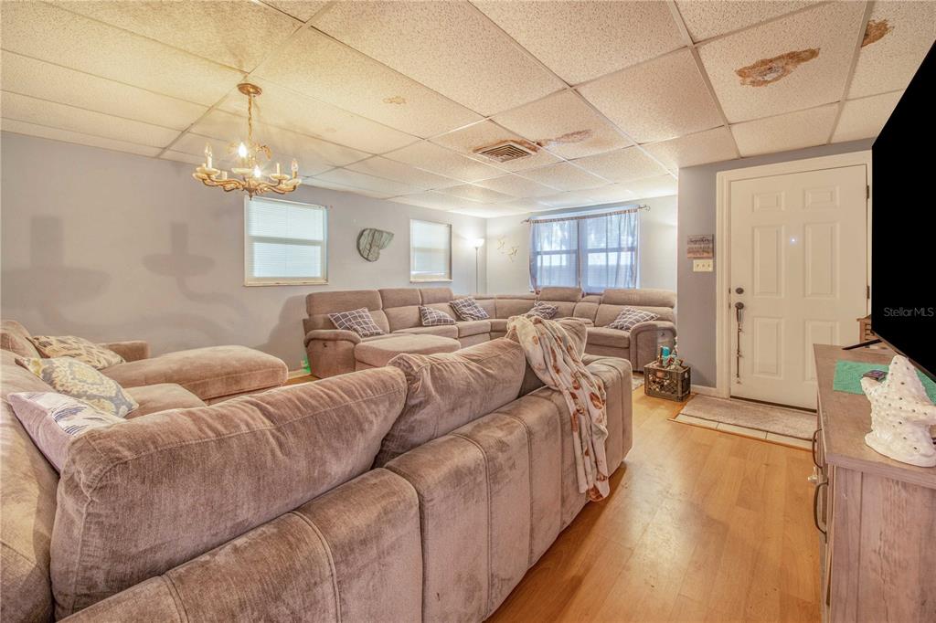 308 Granada Road Auburndale, FL 33823 - Photo 6 of 37 a living room with furniture a flat screen tv and a chandelier