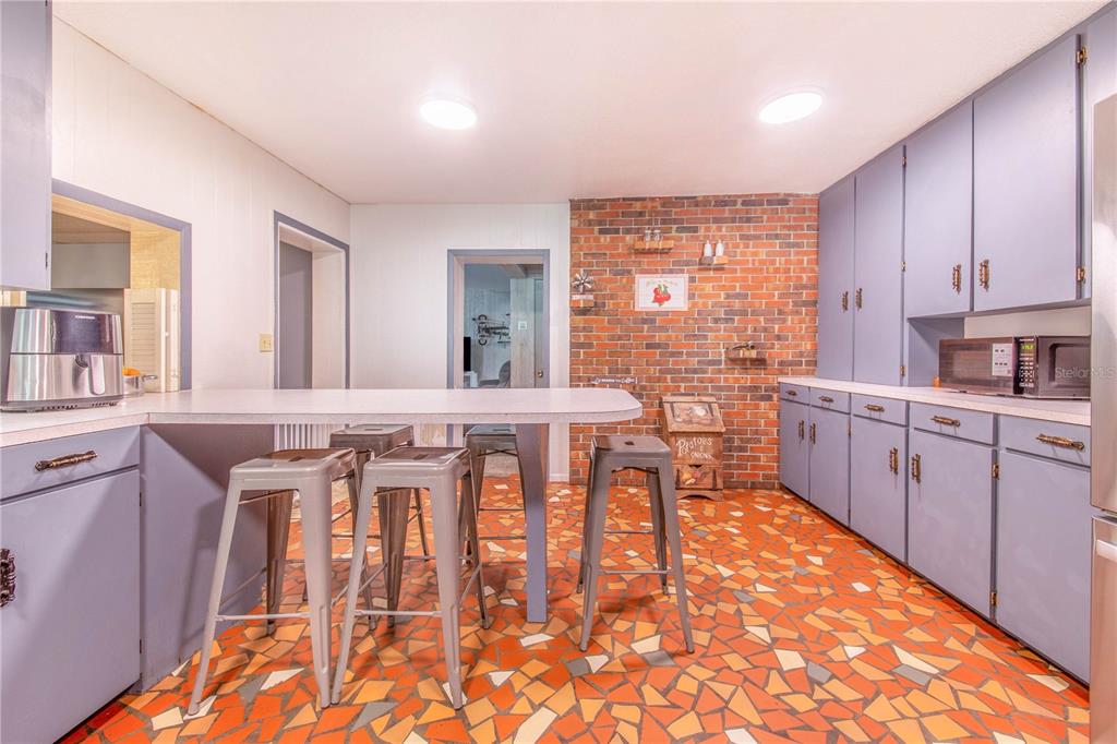 308 Granada Road Auburndale, FL 33823 - Photo 9 of 37 a kitchen with stainless steel appliances kitchen island granite countertop a stove a sink and cabinets