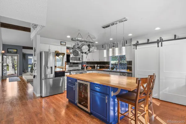 a kitchen with stainless steel appliances granite countertop a kitchen island a stove a table and chairs