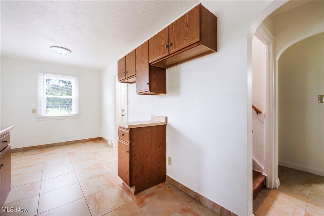 708 South Meridian Road Youngstown, OH 44515 - Photo 14 of 43 Kitchen featuring brown cabinetry, light countertops, arched walkways, and baseboards