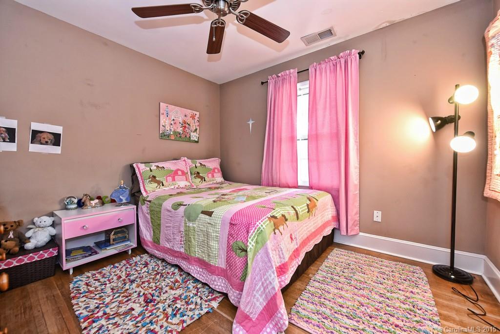 646 Sandridge Road Charlotte, NC 28210 - Photo 18 of 24 a bedroom with a bed and a chandelier