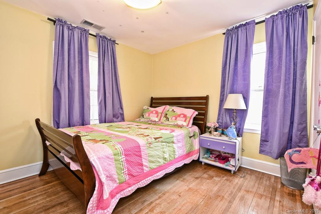646 Sandridge Road Charlotte, NC 28210 - Photo 20 of 24 a bedroom with a bed and a chandelier