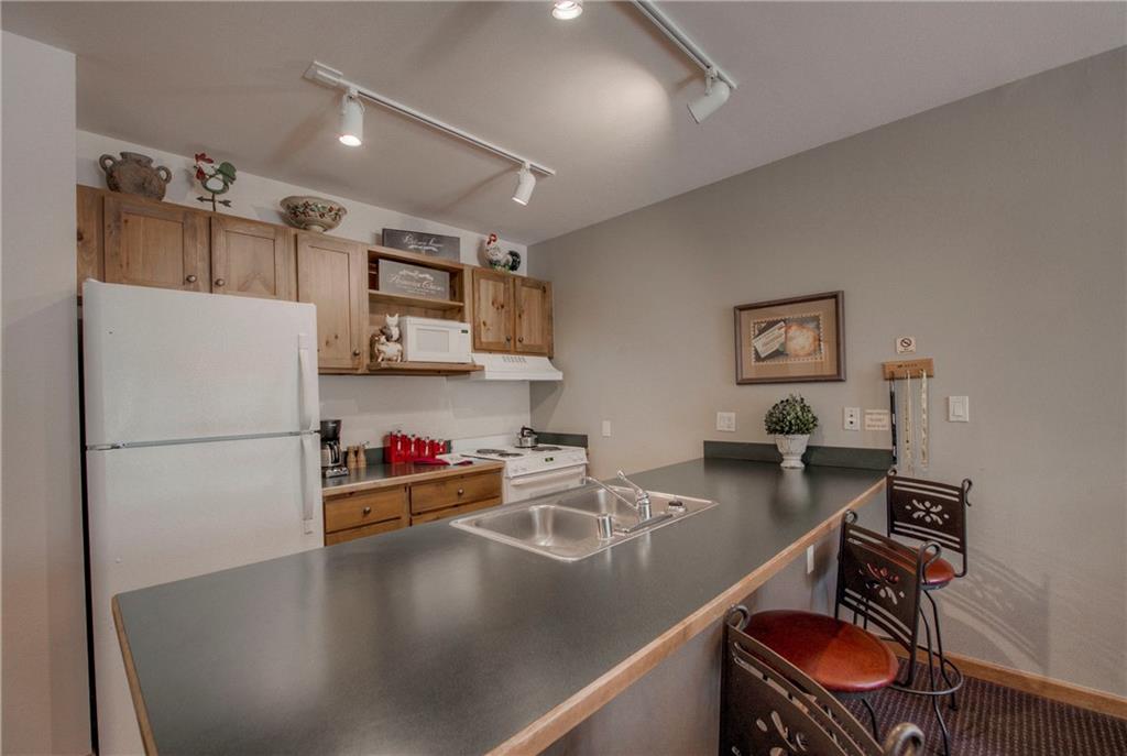 129 River Run Road, Unit 8062 Dillon, CO 80435 - Photo 10 of 35 a view of a kitchen with a refrigerator a sink and a stove with wooden floor