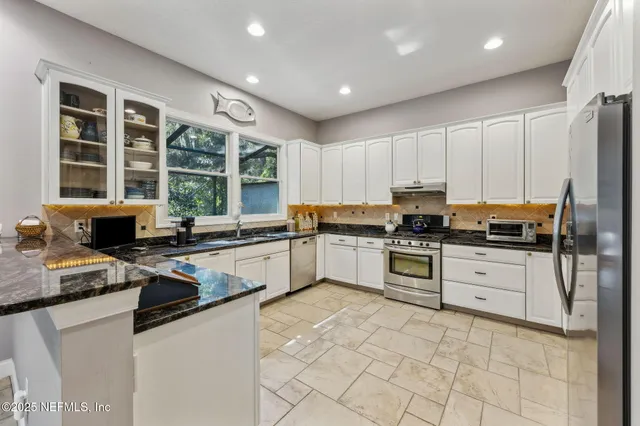 a kitchen with white cabinets stainless steel appliances and sink