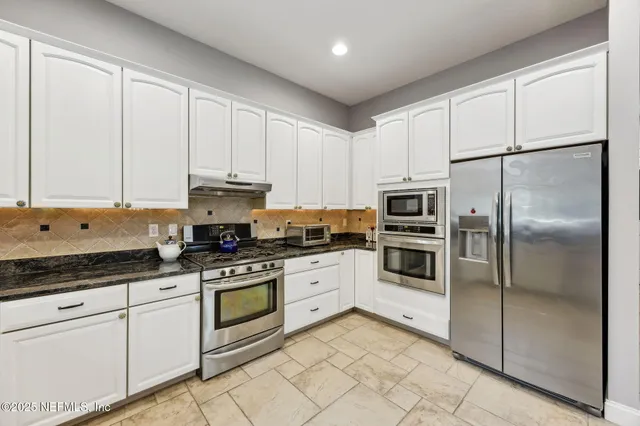 a kitchen with sink and view of living room