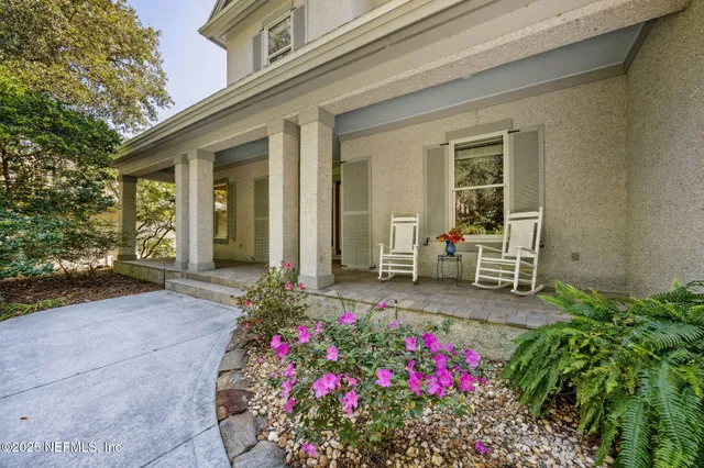 a view of a livingroom with lounge chair and windows