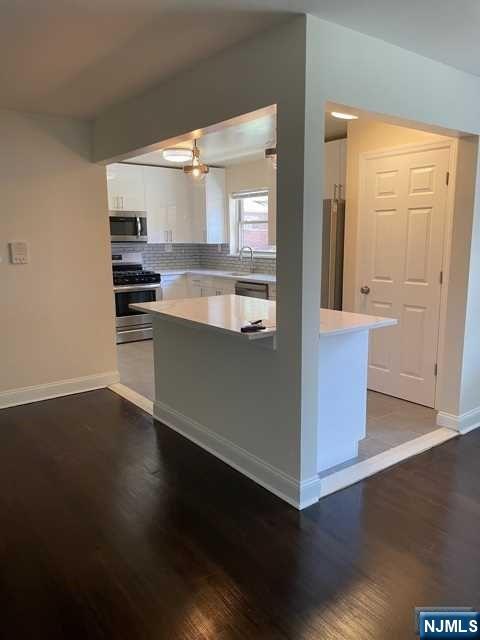 280-320 Oak Street, Unit 290D Ridgewood, NJ 07450 - Photo 5 of 20 an open kitchen with wooden floor and cabinets