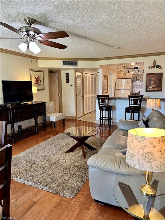 190 Turtle Lake Court, Unit 202 Naples, FL 34105 - Photo 3 of 10 a living room with furniture and a flat screen tv