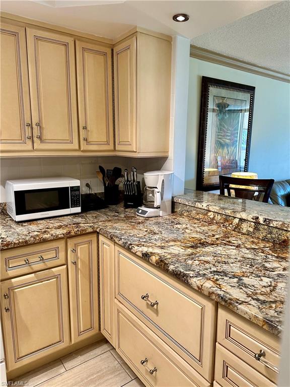 190 Turtle Lake Court, Unit 202 Naples, FL 34105 - Photo 5 of 10 a kitchen with granite countertop a sink and cabinets